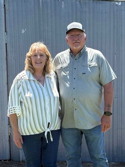 Children's Director Laura Collum, on the left, standing in front of a metal building.
